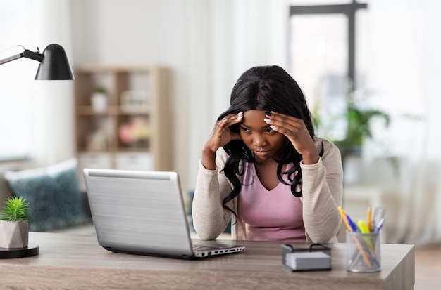 gestresseerde vrouw met laptop die thuis op kantoor werkt
