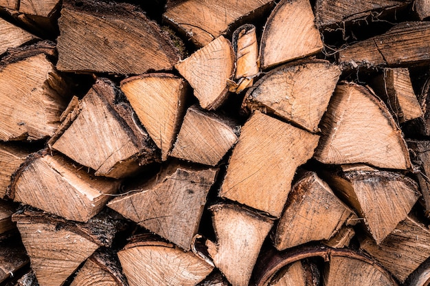 Gestructureerde brandhoutachtergrond van gehakt hout voor het aansteken en verwarmen van het huis. een houtstapel met gestapeld brandhout. de textuur van de berkenboom