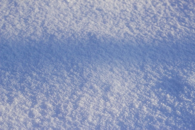 Gestructureerde sneeuwachtergrond met blauwe schaduw in zonnige de winterdag