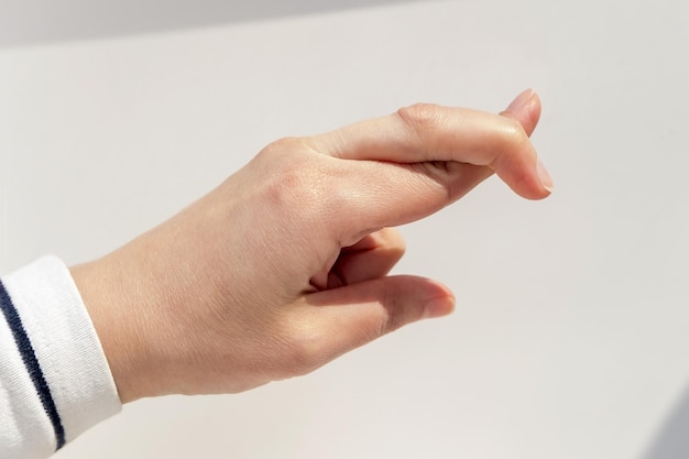 Gesture and body parts concept close up of hand showing two crossed fingers