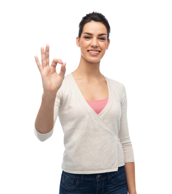 몸짓, 패션, 초상화, 그리고 사람들의 개념 - 흰색 위에 확인 손 사인을 보여주는 중괄호를 들고 행복하게 웃고 있는 젊은 여성