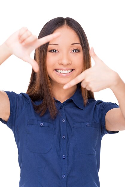 Gesturing finger frame. Beautiful young Asian woman looking at camera and gesturing finger frame