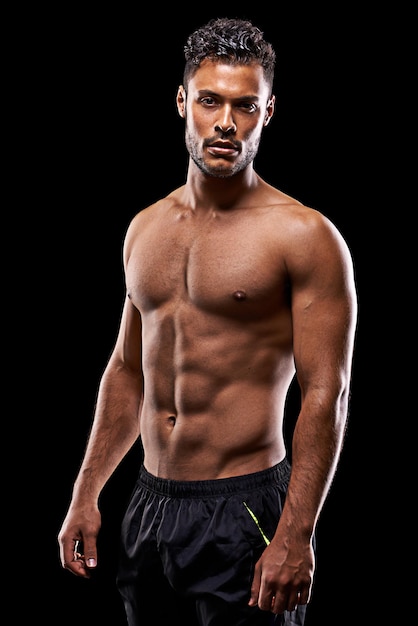 Get big or die trying Studio portrait of a handsome barechested young athlete standing against a black background