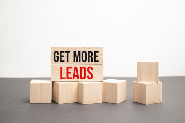 Get More Leads written on wooden cubes on a gray background closeup of wooden elements In the background is a green flower in a tub tax time