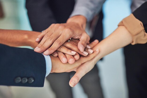 Get together and lets make this work Closeup of a group of unrecognizable businesspeople forming a huddle with their hands while standing in the office during the day