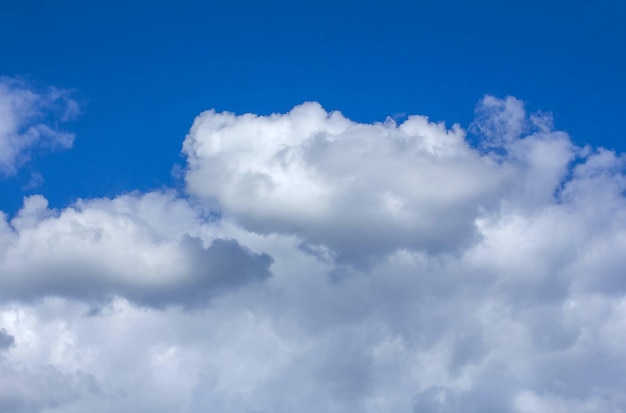 Getextureerde witte wolken op blauwe hemelachtergrond