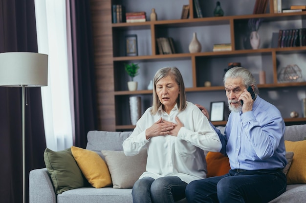 Getrouwd senior paar thuis man belt dokter vrouw heeft ernstige pijn op de borst