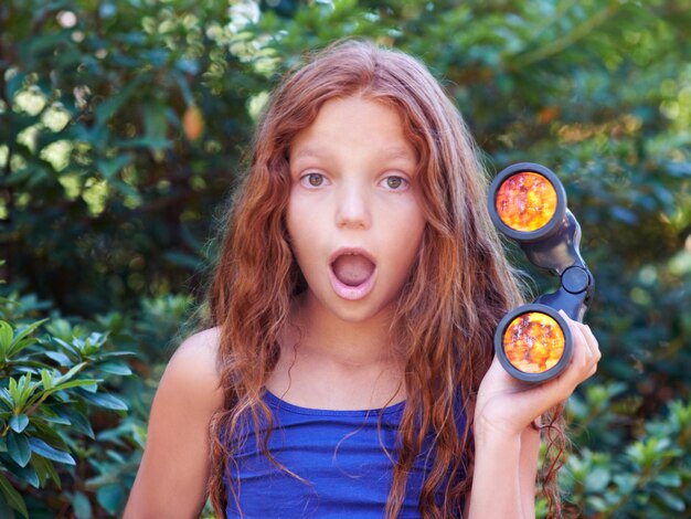 Photo getting a closer look at nature a young child holding binoculars