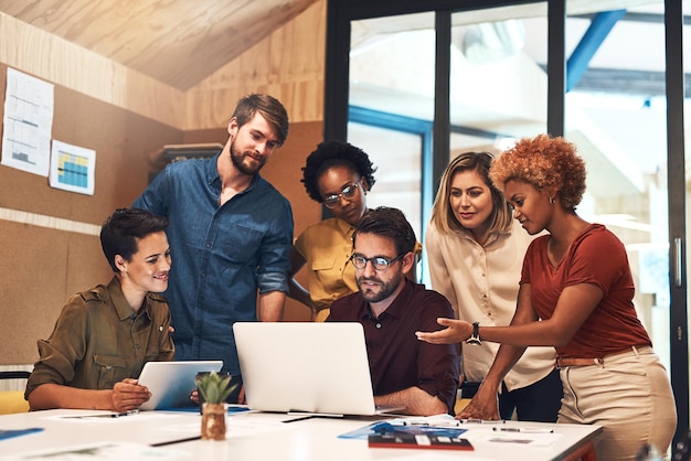 Getting everyone on the same page Shot of a diverse group of businesspeople working together on a laptop in an office