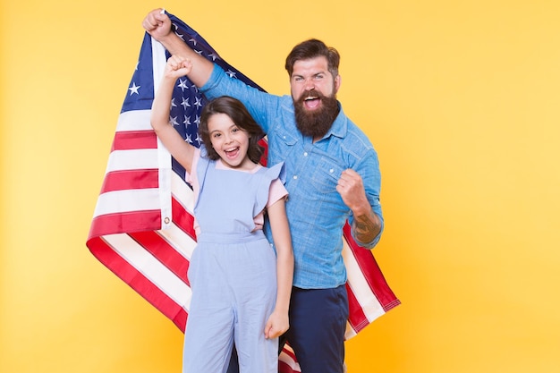 Getting in the holiday spirit Father and small child holding american flag on national holiday Happy family celebrating annual 4th of july holiday Independence day is federal holiday in the usa