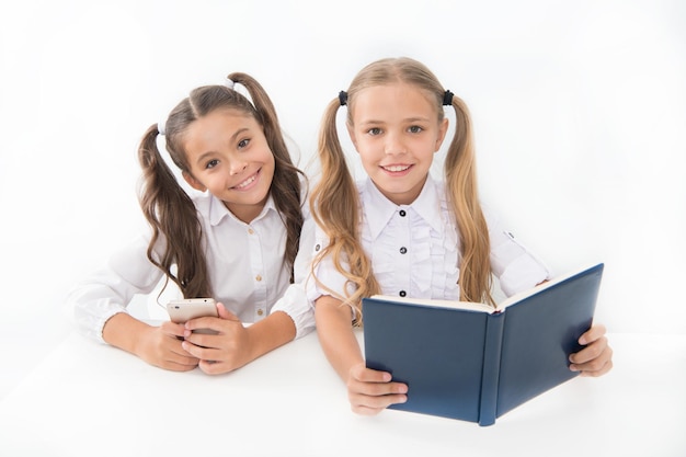 정보 얻기 큰 종이 책 대신 현대적인 데이터 저장 어린 소녀들은 종이 책과 전자책 스마트폰을 읽습니다. 교육 신청 교육 응용 프로그램 휴대 전화 온라인 교육