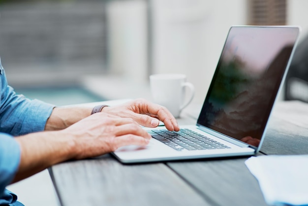 Getting it all typed out Closeup shot of an unrecognizable man using a laptop outdoors