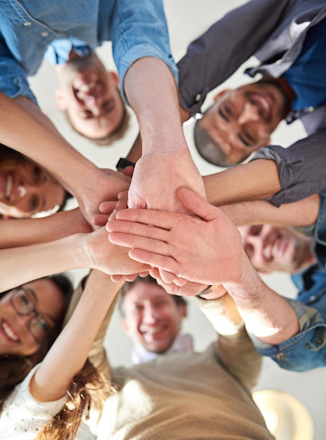 Getting it done through teamwork Low angle shot of a group of coworkers stacking their hands on top of each other