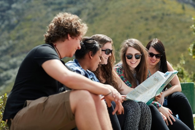 Фото Заблудиться вместе так весело снимок группы друзей, вместе читающих карту во время поездки