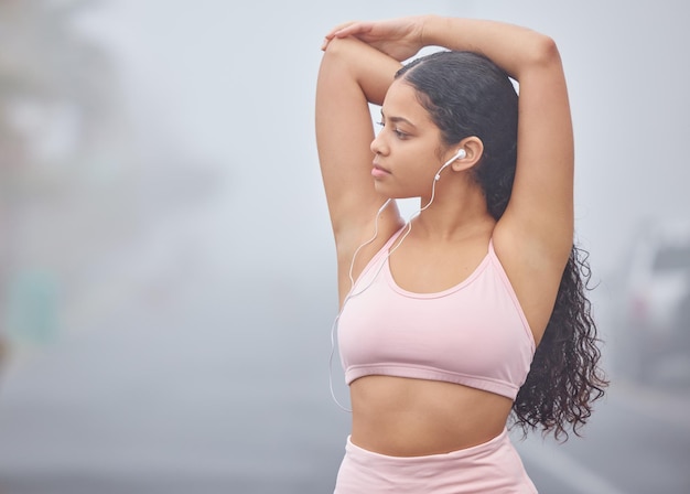 Getting my summer body ready Shot of a young woman listening to music while doing stretches