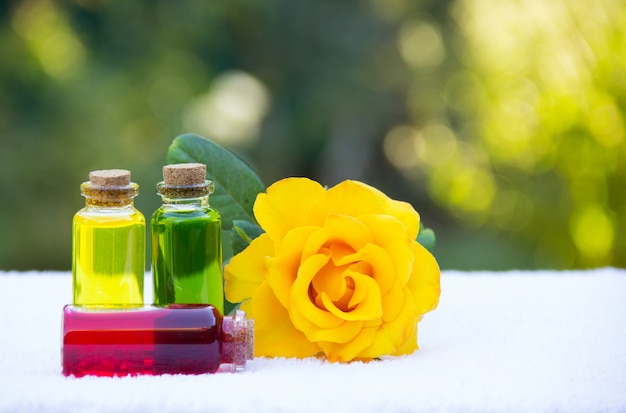 Geurende natuurlijke bloemenoliën in flesjes en gele roos