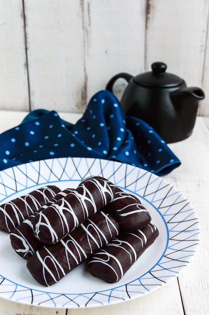 Geurige koekjes van soezendeeg in donkere chocolade bedekt met witte decoratie Verticaal zicht