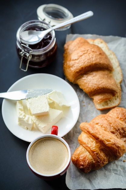 Geurige koffie en croissants met boter op tafel