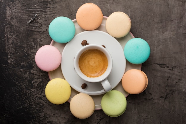 Geurige koffie en kleurrijke macaronkoekjes worden in een cirkel op een bord gerangschikt