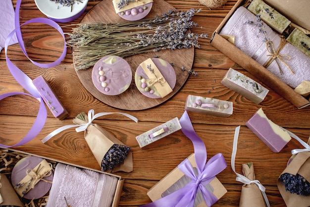 Geurige lavendelboeketten verpakt in ambachtelijk papier met lint natuurlijke zeep en geschenkdozen op een houten tafel Concept van het verpakken van handgemaakte cadeautjes