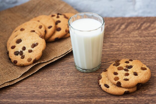 Geurige smakelijke zelfgemaakte koekjes met rozijnen en een glas verse melk op tafel Heerlijk stevig gezond ontbijt Kopieer ruimte hoge resolutie