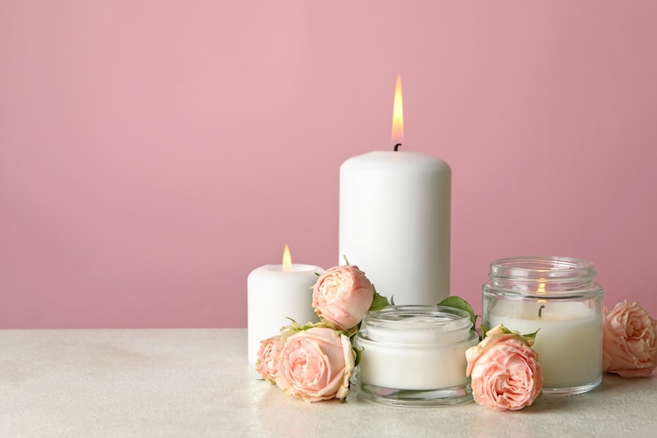 Foto geurkaarsen en rozen op witte tafel tegen roze achtergrond
