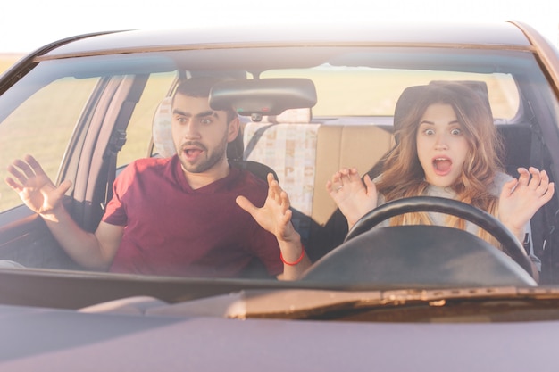 Gevaar op de weg. Gekke jonge vrouw en man hebben auto-ongeluk