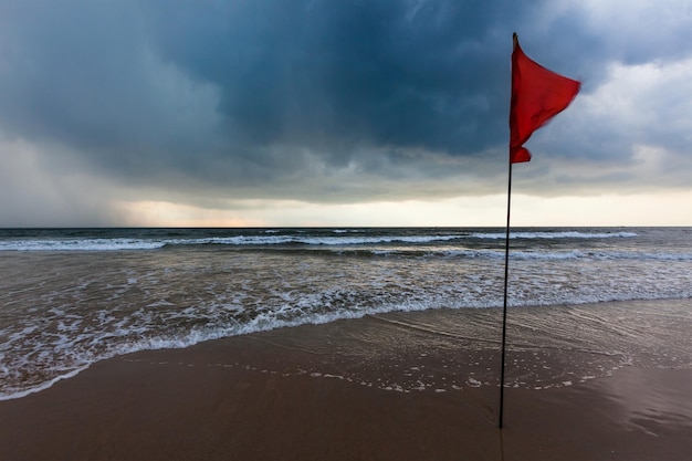 Gevaarconcept achtergrond ernstige stormwaarschuwingsvlaggen op het strand Baga Goa India