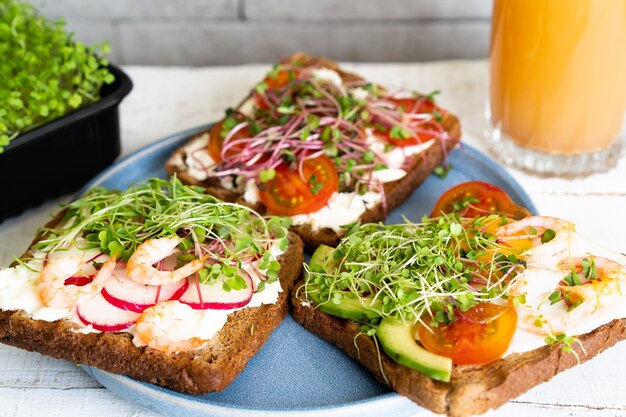 Foto gevarieerd ontbijt, voorgerecht volkoren brood sandwiches, broodroosters met roomkaas, bovenaanzicht.