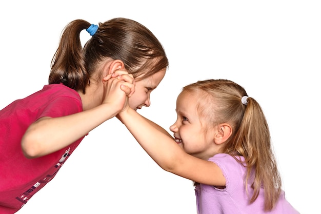 Gevecht tussen twee kleine meisjes Kinderen die gek doen op een witte achtergrond