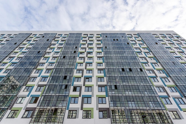 gevel van een nieuw gebouw van witte blauwe en groene kleur met glazen ramen en balkons