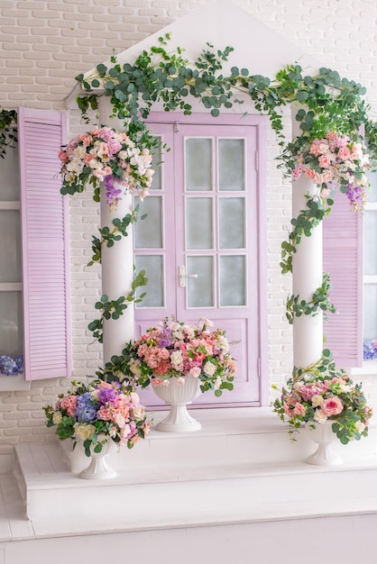 Gevel van een wit en lila gebouw met een veranda versierd met bloemen Fotozone in de fotostudio