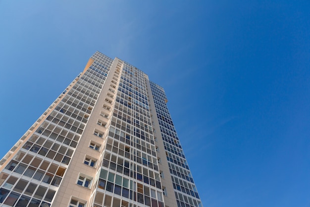 Gevel van nieuw hoog gebouw tegen blauwe hemel