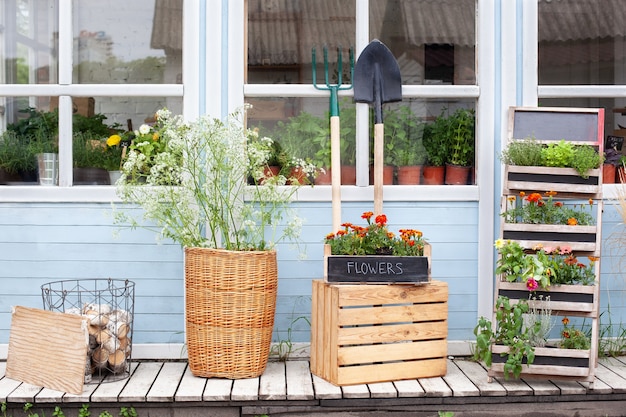 Gevelhuis met tuingereedschap rieten mand en potten bloemen interieur zomer veranda huis