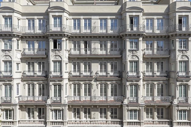 Gevels van oude statige stedelijke woonflatgebouwen met veel balkons, erkers en ramen met balustrades en smeedijzeren leuningen aan de Calle Atocha in Madrid, Spanje