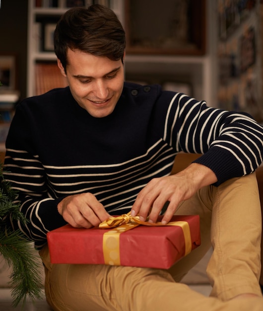 Geven is het beste cadeau van allemaal Shot van een knappe jongeman die zich klaarmaakt voor Kerstmis