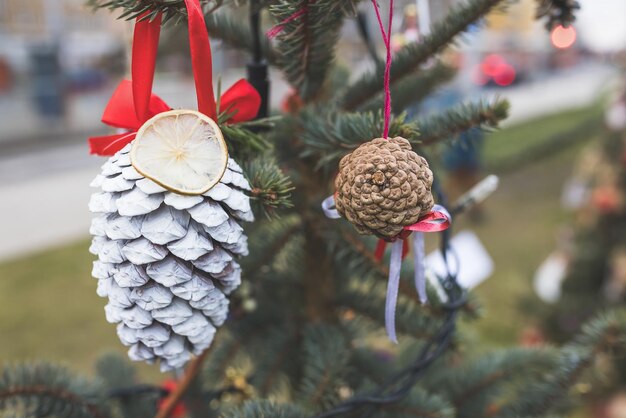 Geverfde witte dennenkegel een gedroogde citroen op de kerstboom DIY decoratie ideeën voor kinderen