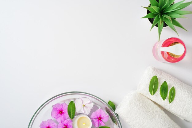 Gevoelige achtergrond intieme hygiëne gel witte handdoeken en een container met roze bloemen voor aromathe...