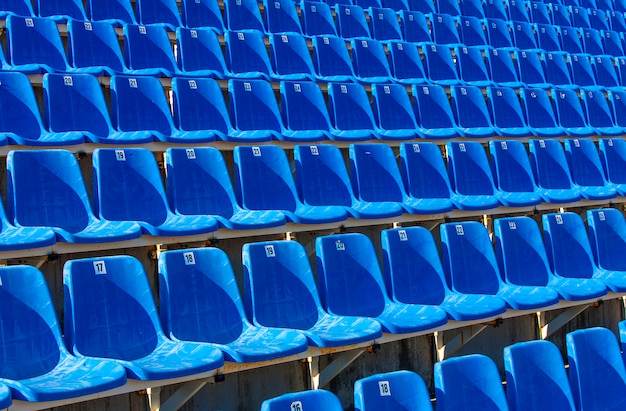 Gevouwen blauwe plastic stoelen op een tijdelijke tribune,