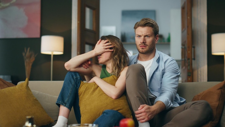 Foto gevreesde echtgenoten kijken tv, zitten 's avonds, genieten van een enge film.