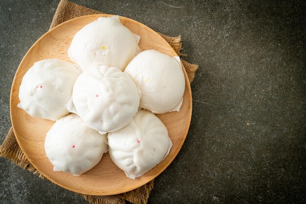 Gevuld gestoomd broodje op houten plaat - Chinees eten stijl