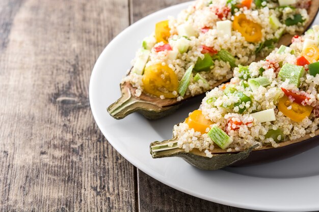 Gevulde aubergine met quinoa en groenten op houten tafel kopie ruimte