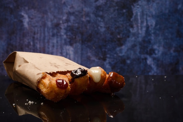 Gevulde churros op zwarte tafel met reflectie