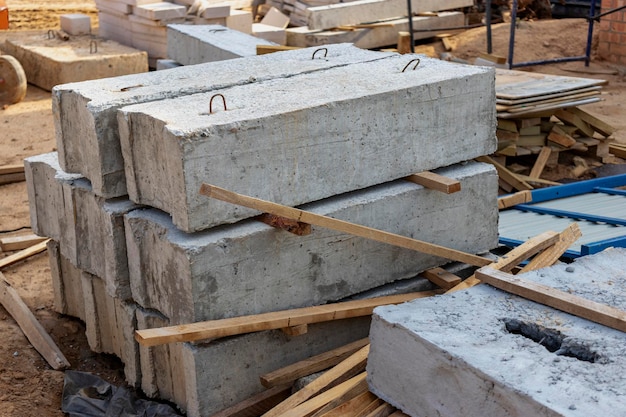 Gewapende betonnen platen en bouwmaterialen op de bouwplaats. Opslag van materialen voor het bouwen van een huis. Industriële techniek.