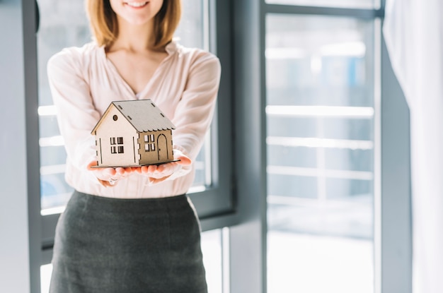 Foto gewasvrouw die stuk speelgoed huis tonen