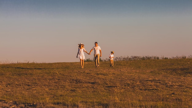 Geweldig landschap in de Karpaten Vrolijke ouders lopen hand in hand jongetje wandelen in de buurt van hen Vreedzame familie tijd op het platteland Vertrouwen relatie concept