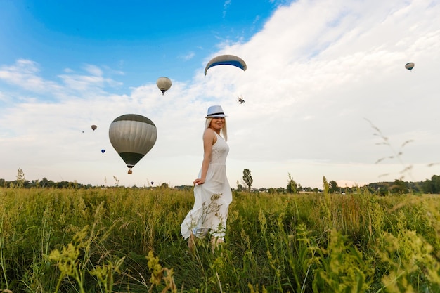 Geweldig uitzicht met vrouw en luchtballon. Artistieke foto. Schoonheid wereld. Het gevoel van volledige vrijheid
