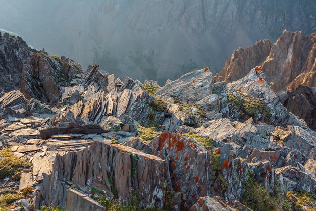 Geweldig uitzicht op de bergen vanaf klif op zeer grote hoogte schilderachtig alpenlandschap met rand van afgrond met scherpe rotsen tegen grote bergwand prachtig landschap aan rand van afgrond met scherpe stenen