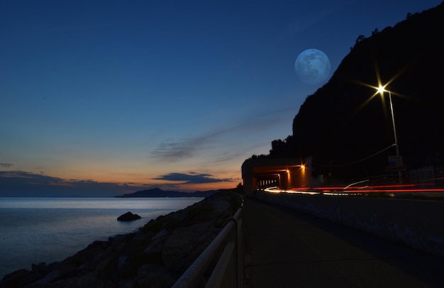 Geweldige gigantische maan weerspiegeld in de zee aan de Ligurische kust