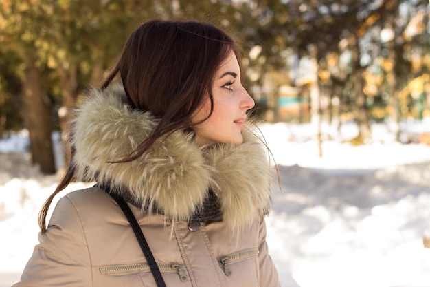 Geweldige schattige vrouw in de winter genietend van de winter in het park